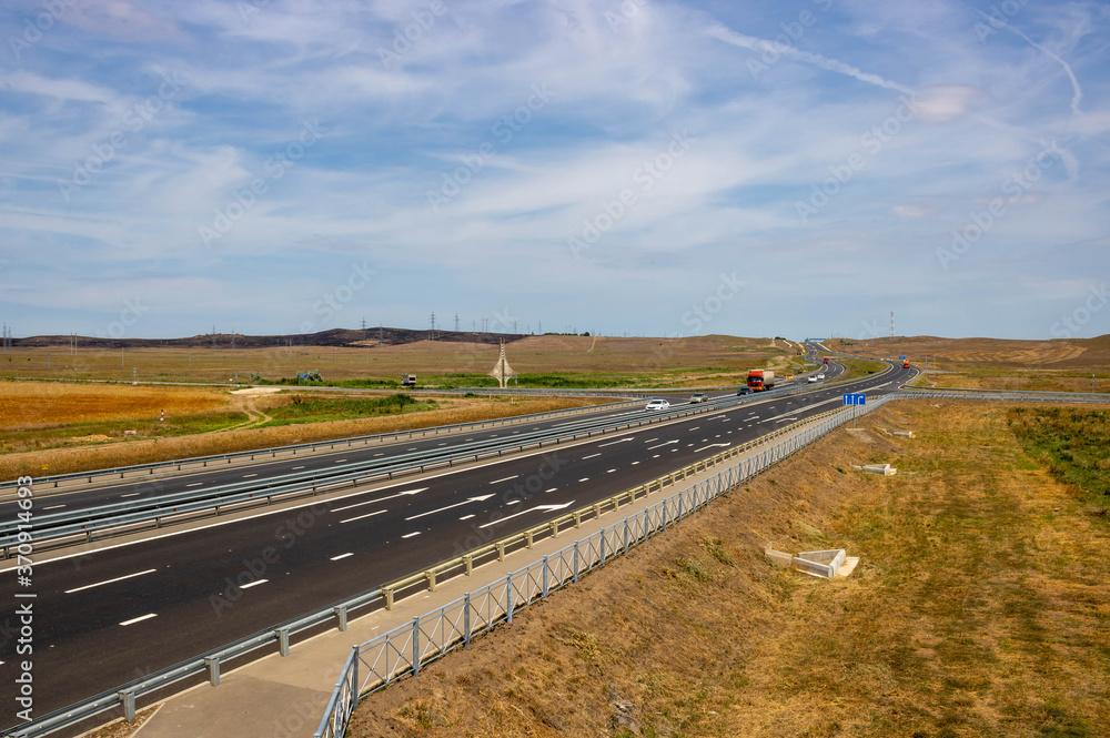 highway in steppe against a blue sky,long road stretching out into the distance.