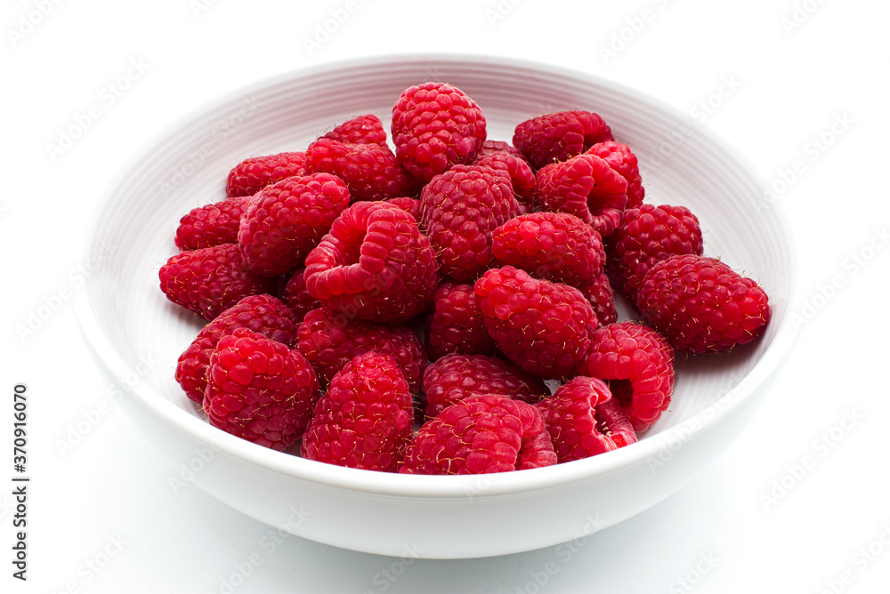 Fresh and sweet raspberries in a white bowl, isolated on white background Fresh and sweet raspberries in a white bowl, isolated on white background