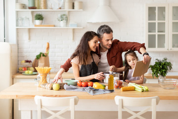 Happy family cooking together at home kitchen