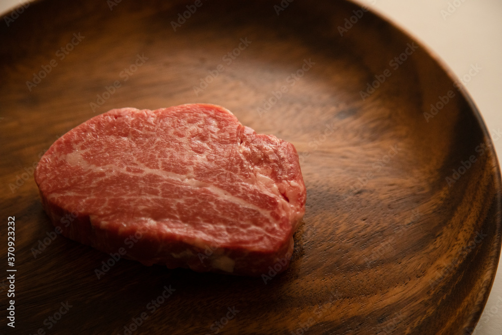 Raw meat on the wooden plate Raw meat on the wooden plate