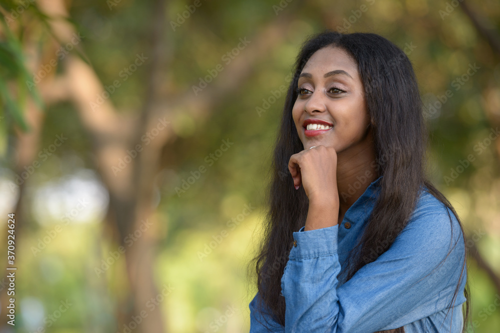 Happy young beautiful African woman at the park outdoors Happy young beautiful African woman at the park outdoors