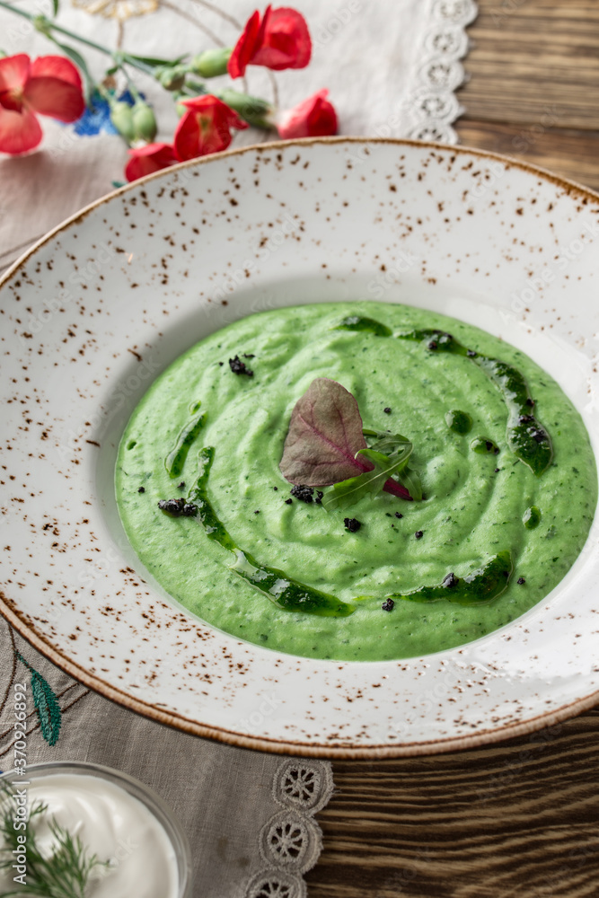 summer healthy green spinach soup on white plate on wooden table summer healthy green spinach soup on white plate on wooden table