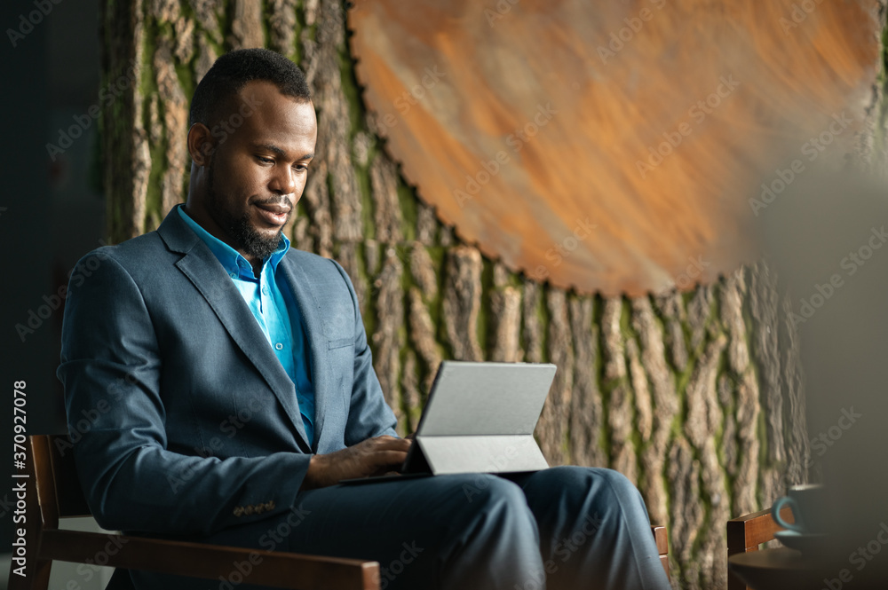 North African businessman sitting in a lounge working on a digital tablet North African businessman sitting in a lounge working on a digital tablet