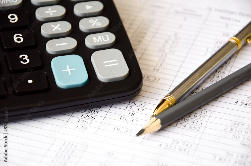 financing. calculator and pen heals on a financial chart financing. calculator and pen heals on a financial chart