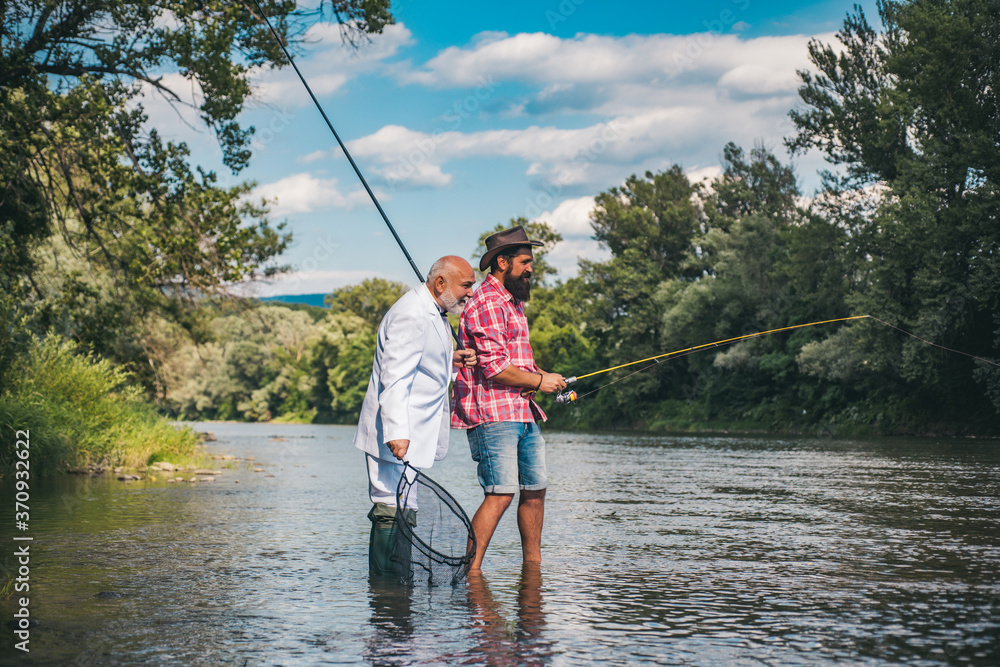 Fishermen fishing equipment. Friends gone fishing. Male hobby fun. Fly fish hobby of man in checkered shirt. Sports. Guy fly fishing. Retired businessman. Fishermen fishing equipment. Friends gone fishing. Male hobby fun. Fly fish hobby of man in checkered shirt. Sports. Guy fly fishing. Retired businessman.