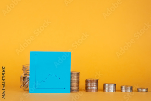 Canvas Print financial crisis. pile of coins with a graph for a fall.