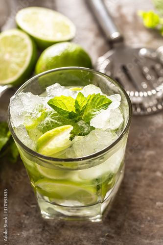 Mojito cocktail drink with white rum lime mint herbs and soda on the bar counter