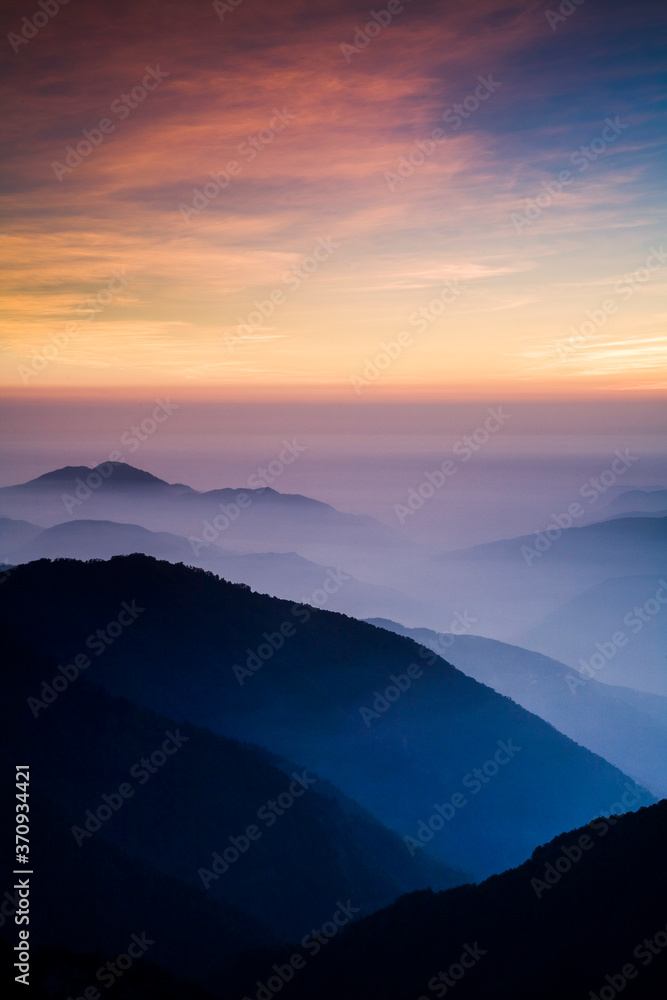 Layers of magnificent mountains at sunset with colorful clouds background. Hehuan Mountain in Taiwan, Asia. Taiwan Central Mountain Range.