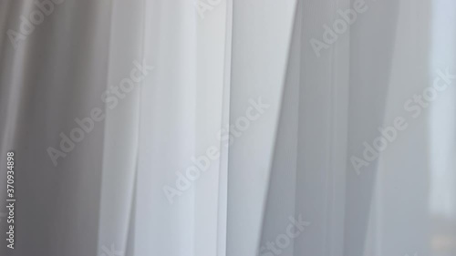 Waving white tulle near the window