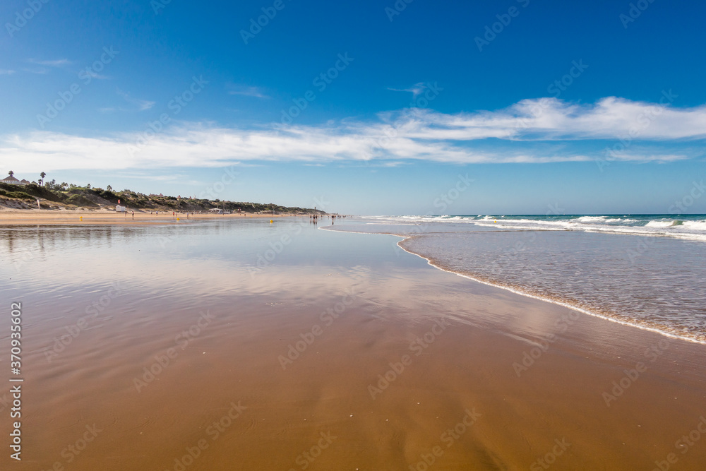 La Barrosa beach in Sancti Petri, Cádiz, with a large amount of sand without water as the tide is low La Barrosa beach in Sancti Petri, Cádiz, with a large amount of sand without water as the tide is low