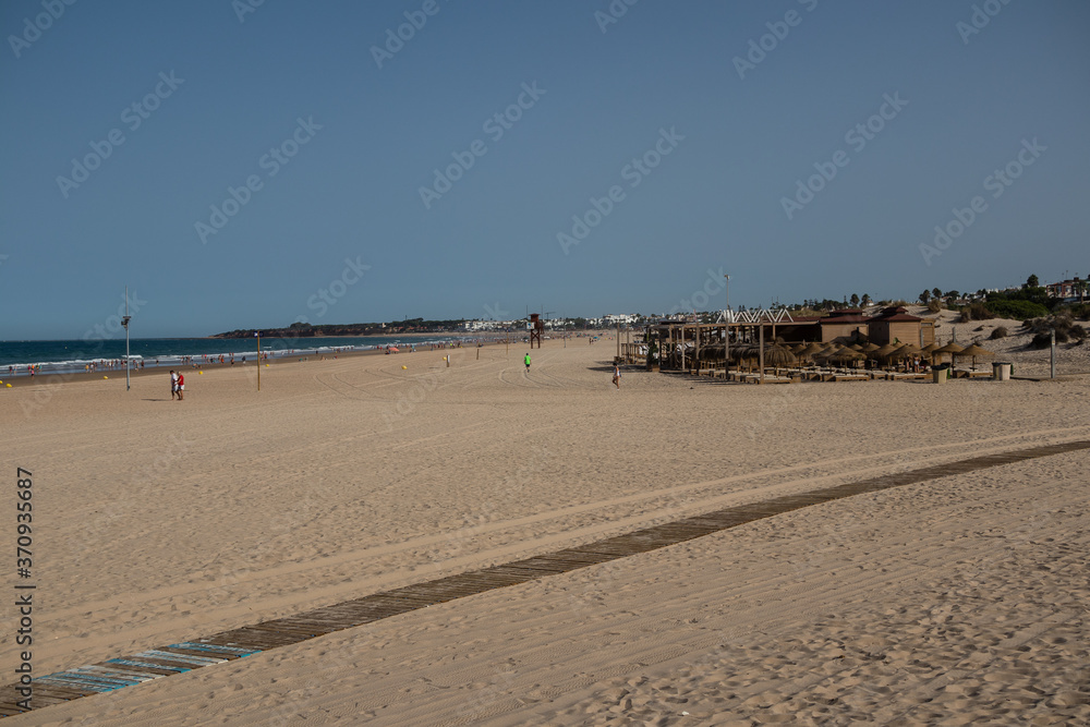 La Barrosa beach in Sancti Petri, Cádiz, with a large amount of sand without water as the tide is low La Barrosa beach in Sancti Petri, Cádiz, with a large amount of sand without water as the tide is low
