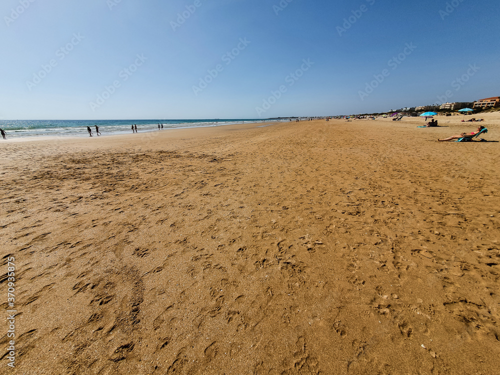 La Barrosa beach in Sancti Petri, Cádiz, with a large amount of sand without water as the tide is low La Barrosa beach in Sancti Petri, Cádiz, with a large amount of sand without water as the tide is low
