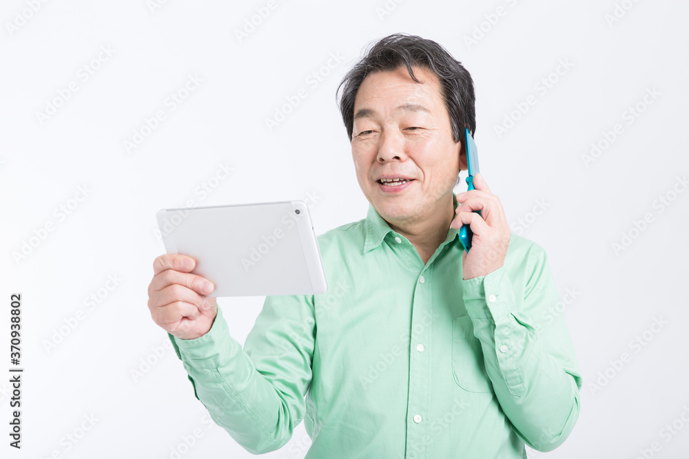 タブレットPCを見ながら電話をする男性
