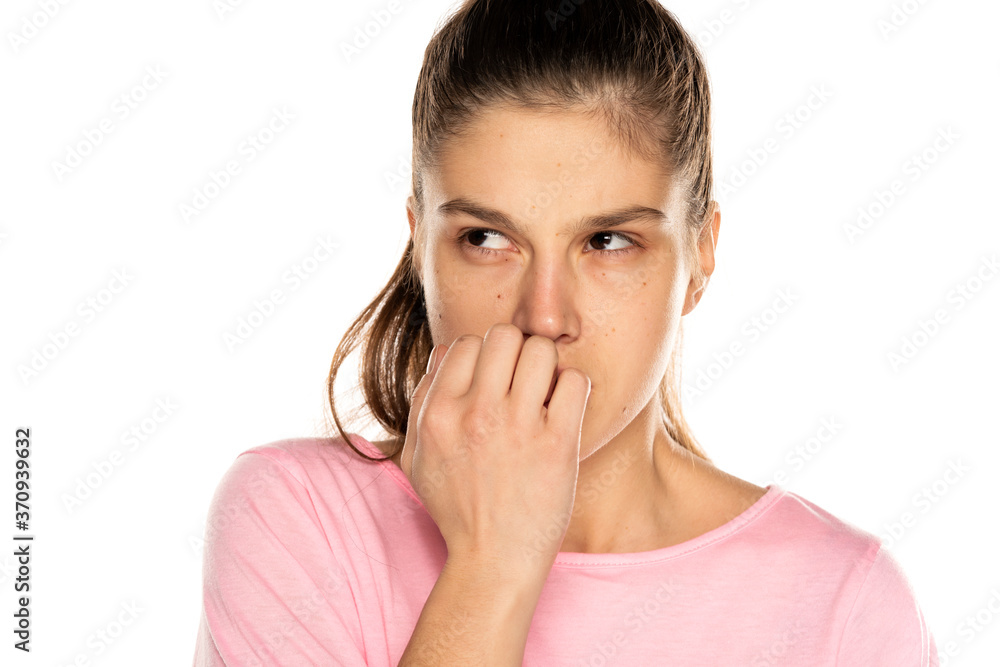 Portrait of young nervous woman biting her nails Portrait of young nervous woman biting her nails