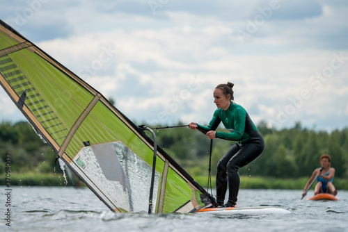 Woman learning windsurfing on a lake