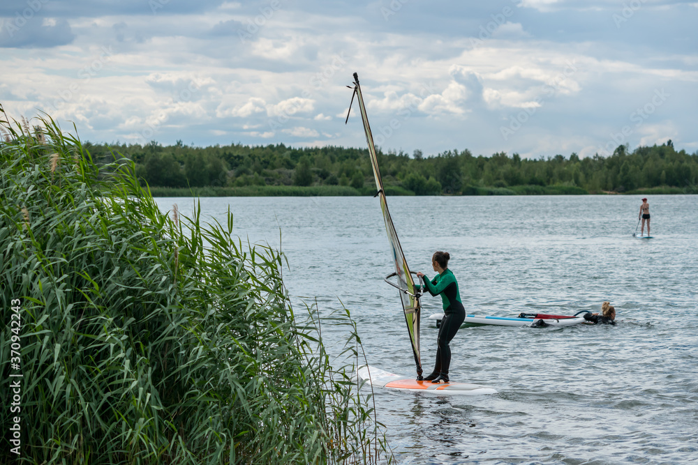 Woman learning windsurfing on a lake Woman learning windsurfing on a lake