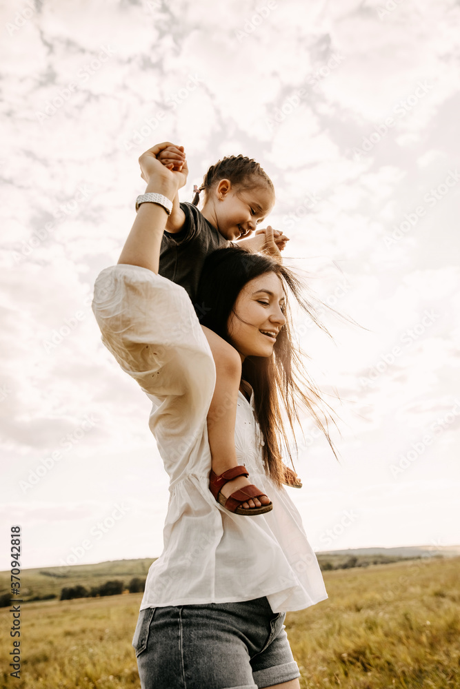 Mother and daughter playing in a field on a summer day.