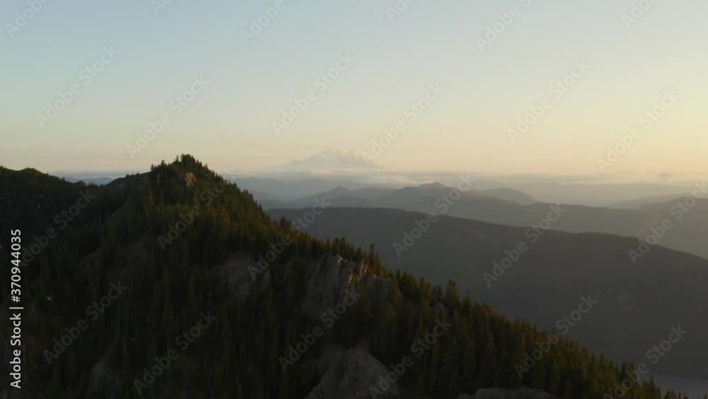 Slow moving parallax effect with ridge in foreground and mountain range in background, aerial shot during dusk, golden hour Slow moving parallax effect with ridge in foreground and mountain range in background, aerial shot during dusk, golden hour