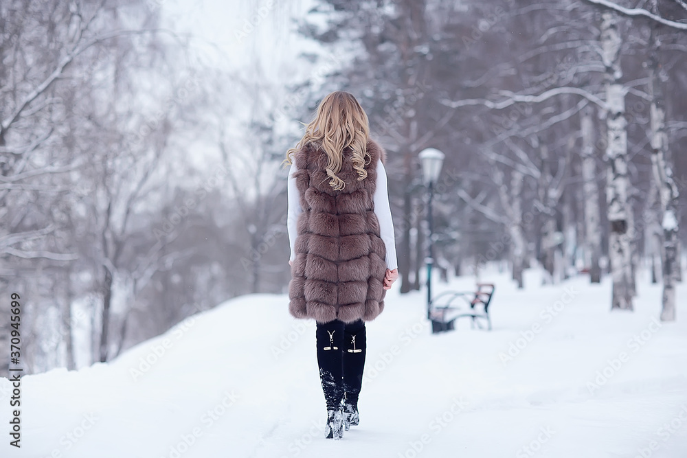girl in a fur vest walks in the winter outside / adult young model in winter clothes fur girl in a fur vest walks in the winter outside / adult young model in winter clothes fur