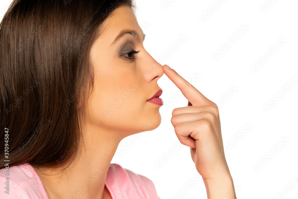 Young beautiful woman touches her nose Young beautiful woman touches her nose