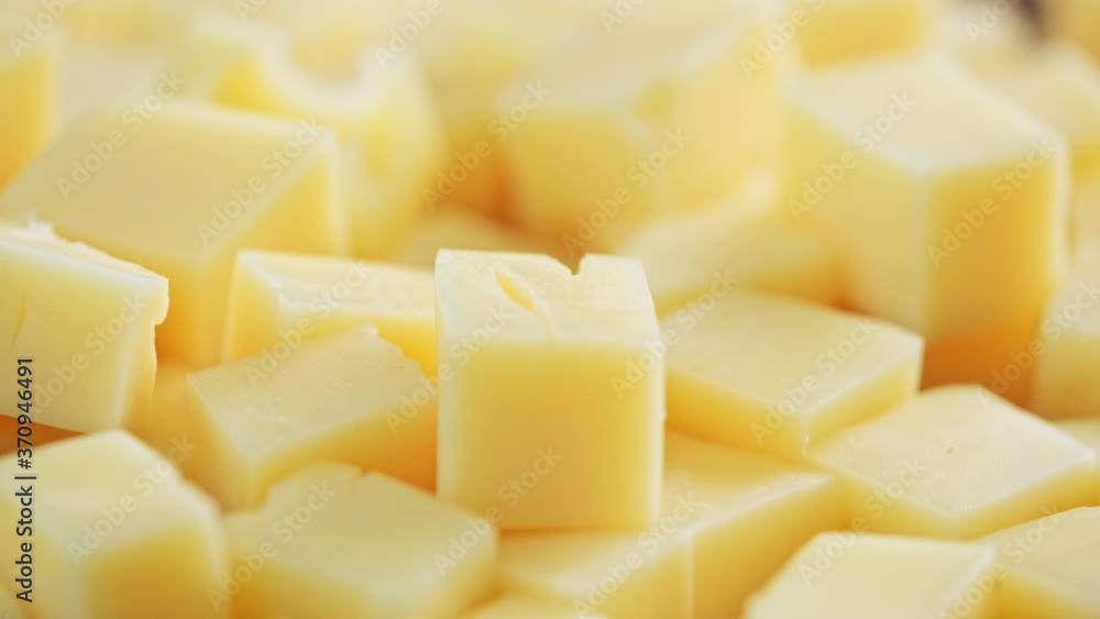 Yellow diced cheese is rotating. Cubes of cheese Yellow diced cheese is rotating. Cubes of cheese