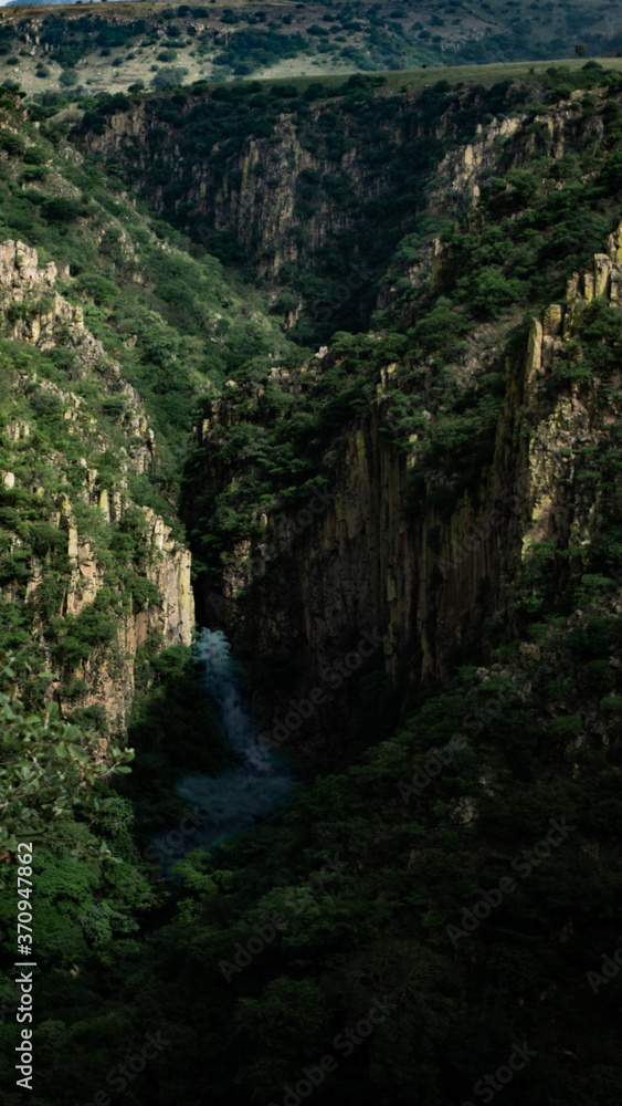 Obraz premium Waterfall and river in cliff canyon