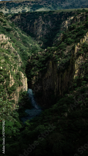 Waterfall and river in cliff canyon