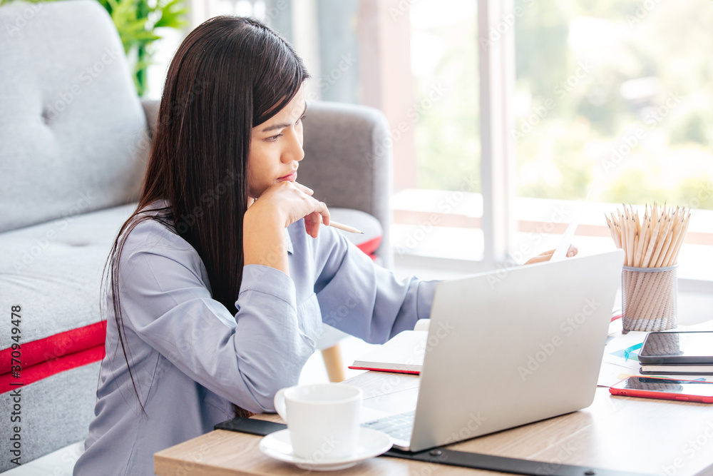 Young Cute Woman feels happy while video call Meeting on Work For Home Period. COVID-19 Lock Down. Copy Space and Warm Tone. Young Cute Woman feels happy while video call Meeting on Work For Home Period. COVID-19 Lock Down. Copy Space and Warm Tone.