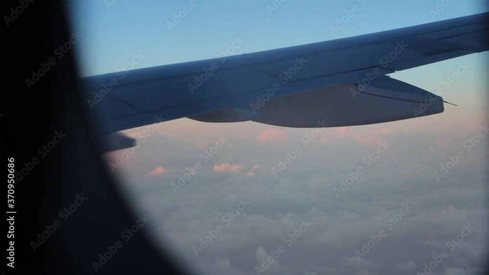 View From Airplane Window Above Pink Sunrise Clouds At 30,000 Feet With Wing And Fuel Tank In Foreground View From Airplane Window Above Pink Sunrise Clouds At 30,000 Feet With Wing And Fuel Tank In Foreground