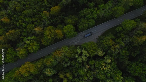Wallpaper Mural Aerial top shot above a street leading through a forest while a car is passing by the diagonal orientated road. Start your travel trip today! Torontodigital.ca