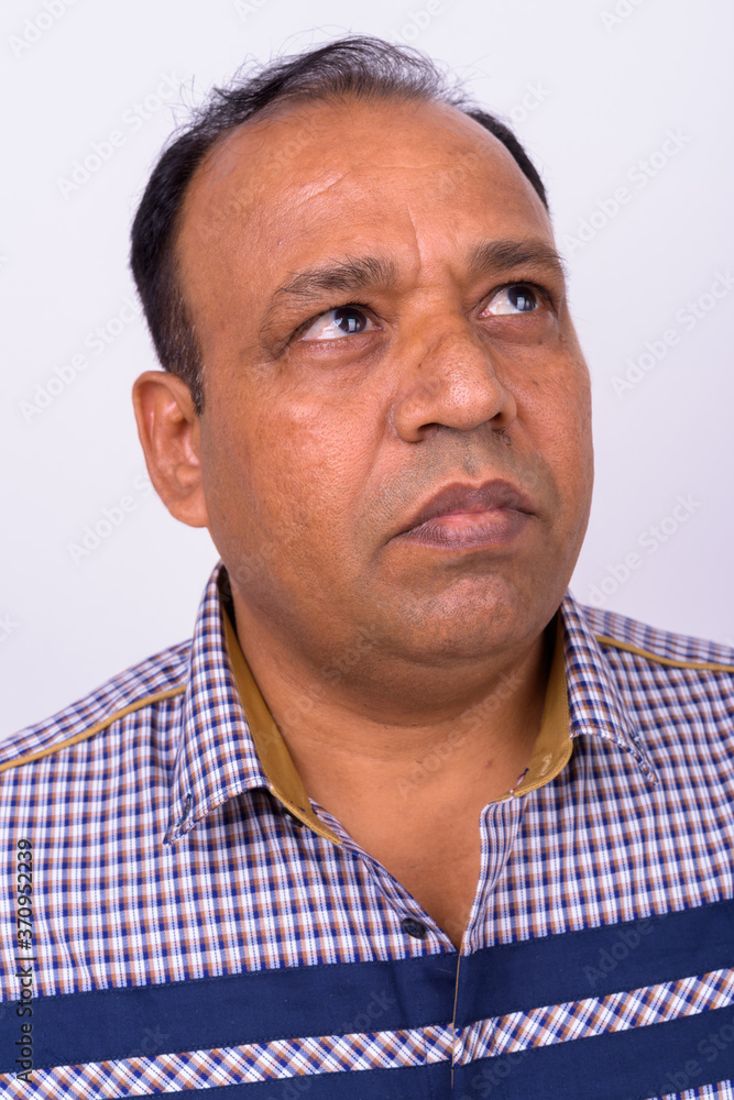 Obraz premium Portrait of mature overweight Indian businessman against white background