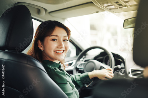 Pretty businesswoman smiling and driving in her car