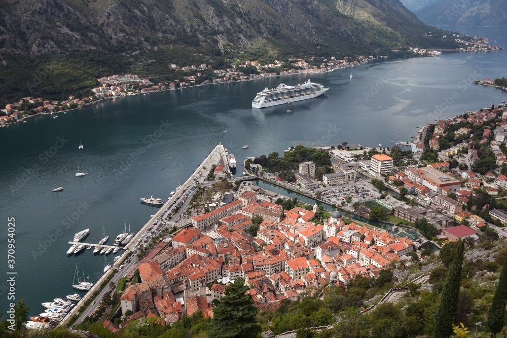 beautiful scenery of Budva harbor with sightseeing cruise and village seen from above