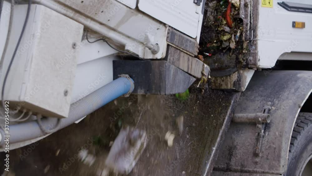 Close up of garbage truck picking up a city trash bin. Collecting waste. Stop pollution Close up of garbage truck picking up a city trash bin. Collecting waste. Stop pollution