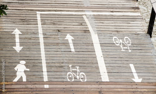 Urban boardwalk with spray-painted wayfinding directional signage for pedestrian and cyclist lanes photo