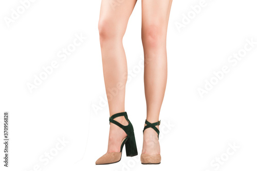 Woman legs in green and beige sandals on heels.