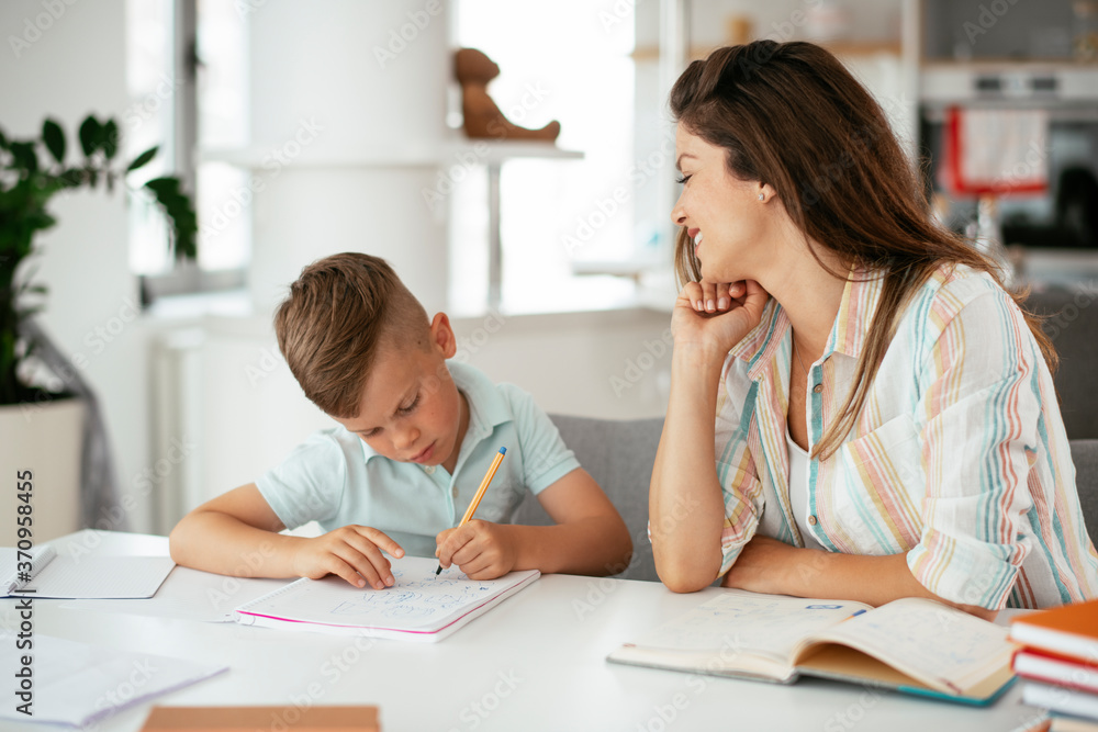 Mother helping her sons with homework at home. Little boys learning at home.. Mother helping her sons with homework at home. Little boys learning at home..