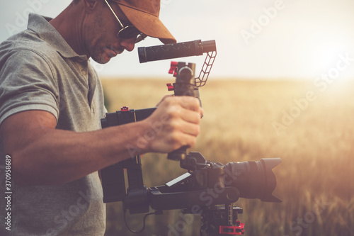 Men Taking Video Shot Using Digital Camera and Gimbal Stabilizator photo