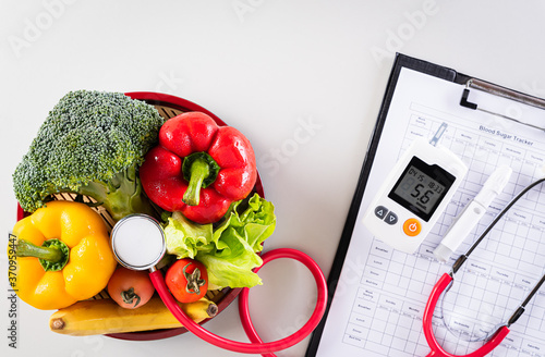 World diabetes day and healthcare concept. Patient's blood sugar control, diabetic measurement, and healthy food eating nutrition on gray background. photo