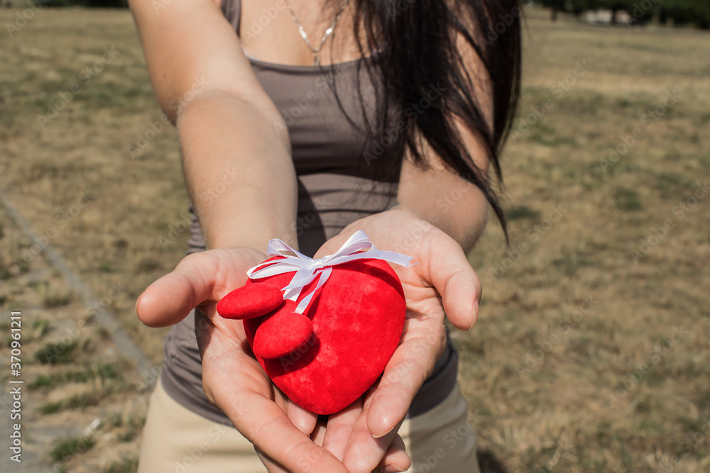 people, relationships and the concept of love in the world, close-up of the hand of a woman who holds the heart people, relationships and the concept of love in the world, close-up of the hand of a woman who holds the heart