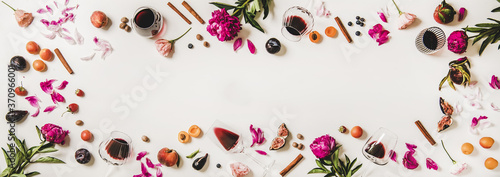 Red wine in glasses with flavours symbols. Flat-lay of wine glasses, fruit, flowers, spices and berries over white background, top view, copy space. Wine tasting, winery or Beaujolais Nouveau concept