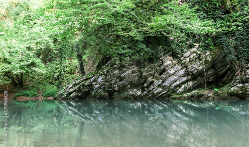 Beautiful turquoise lake in mountains forest. Great design for any purposes. Summer wild nature landscape. Forest in the mountains background.