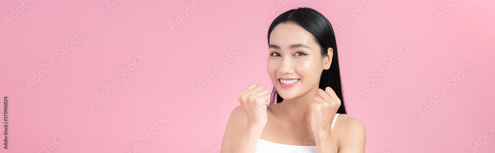 Excited beautiful young woman posing with perfect skin over pink background.