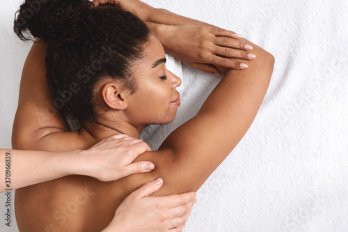 Closeup of black young woman having healing body massage photo