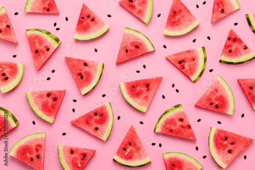 Watermelon colorful pattern on pink background. Fresh red watermelon slices closeup, wallpaper, top view. Creative summer concept, fashionable trendy flat lay