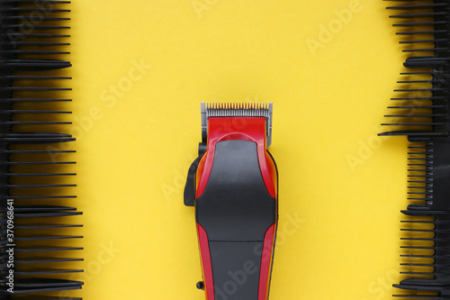 Hair clipper close-up on a yellow background with nozzles of different sizes. photo