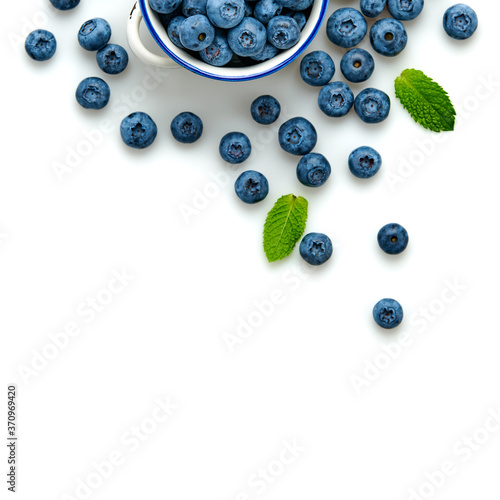 Blueberry in ceramic bowl isolated on white. Fresh blueberry closeup, healthy diet concept. Ripe organic bilberry, mint leaf creative composition. Juicy berries background, top view.