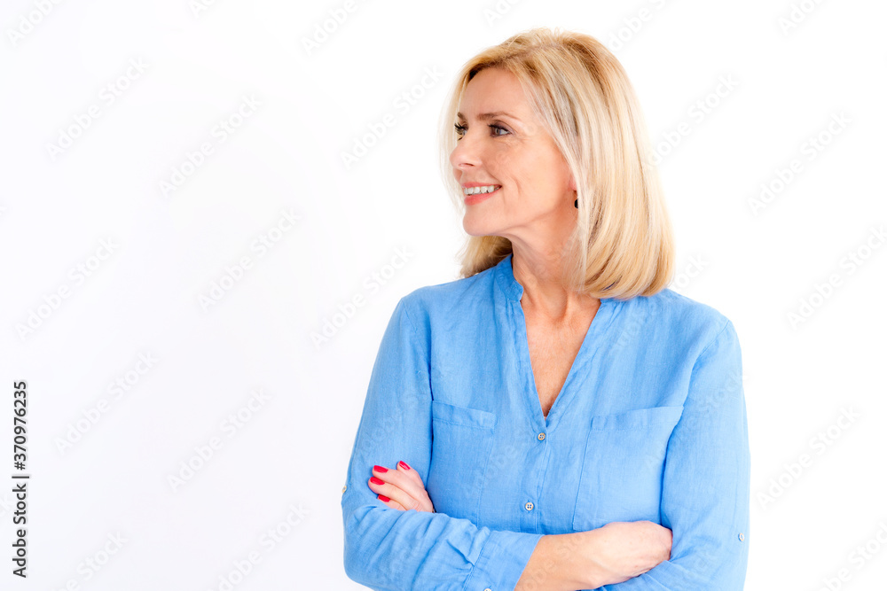 Attractive senior woman posing at isolated white background while looking away and smiling