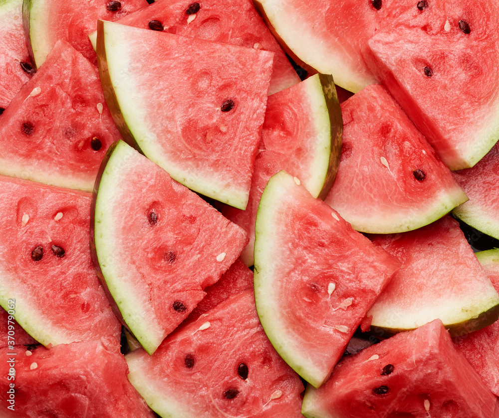 many sliced terrugol pieces of ripe red watermelon with brown seeds many sliced terrugol pieces of ripe red watermelon with brown seeds