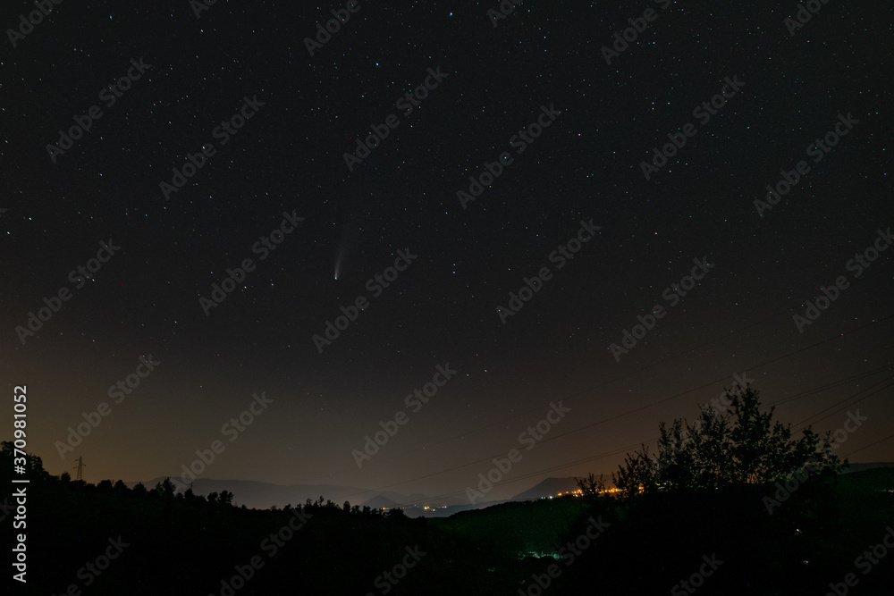 night sky with stars and neowise comet with a landscape
